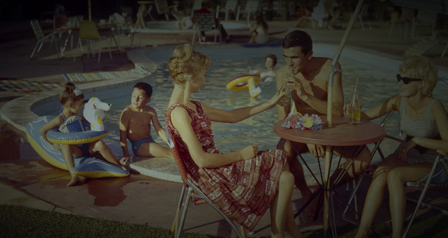 Family dining next to a motel pool. 
