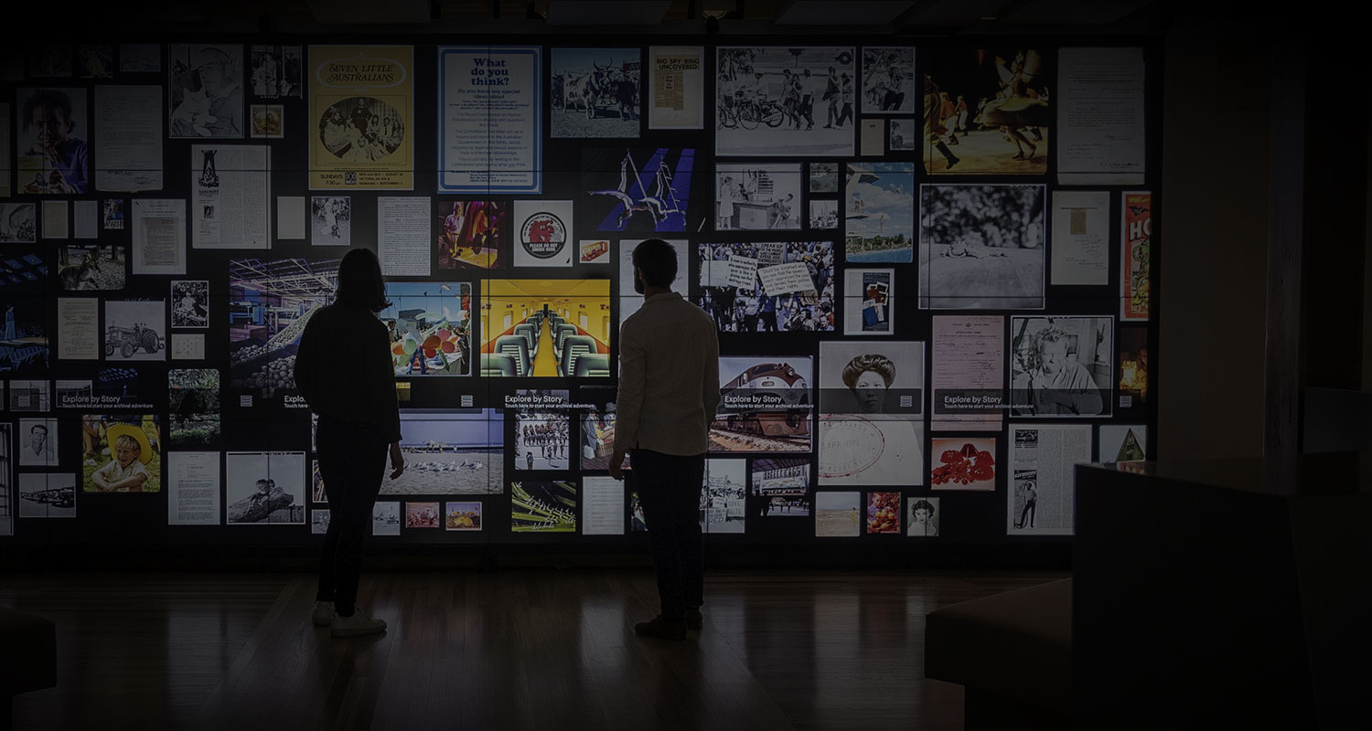 2 people looking at the Archives' photo-wall