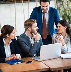 Professionals gathered around a laptop 