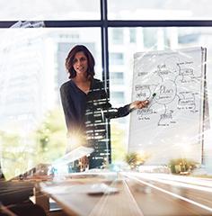 Professional presenting in front of a whiteboard.