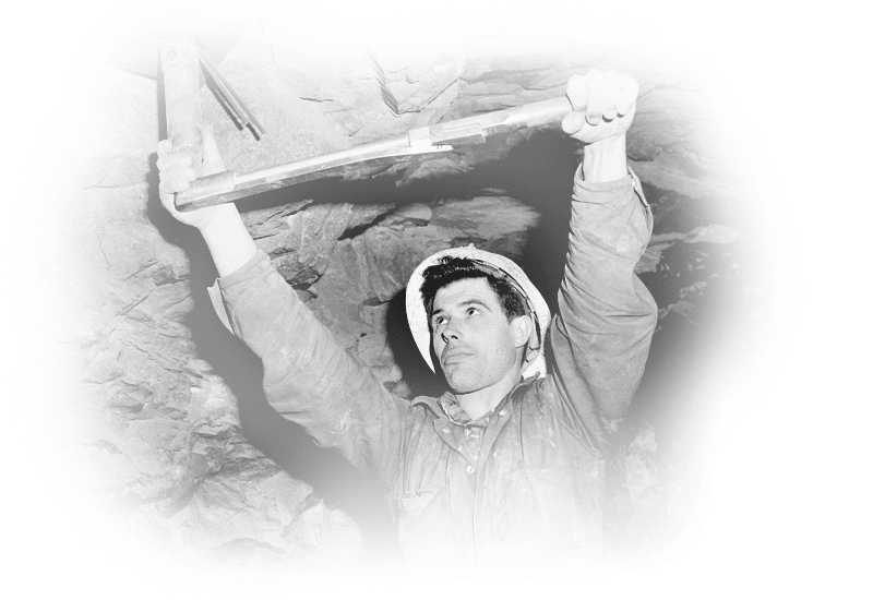 Eugenio Labbrozi uses a tension wrench to set a rock-bolt in the roof, 1960.