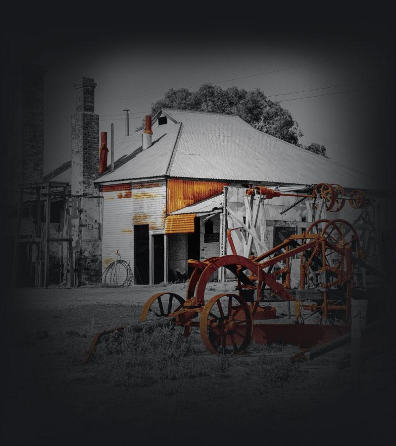 An abandoned old house and farm machinery