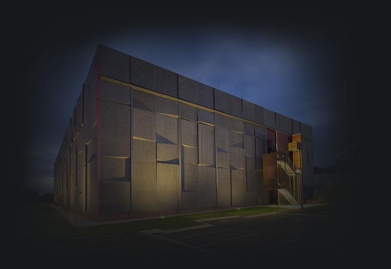 National Archives of Australia Preservation Facility under external lighting with evening sky.