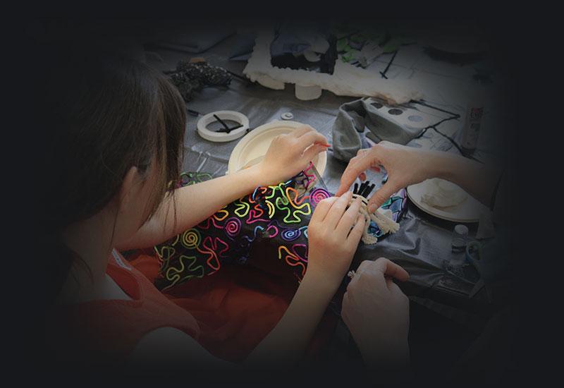 A young blind girl making art.