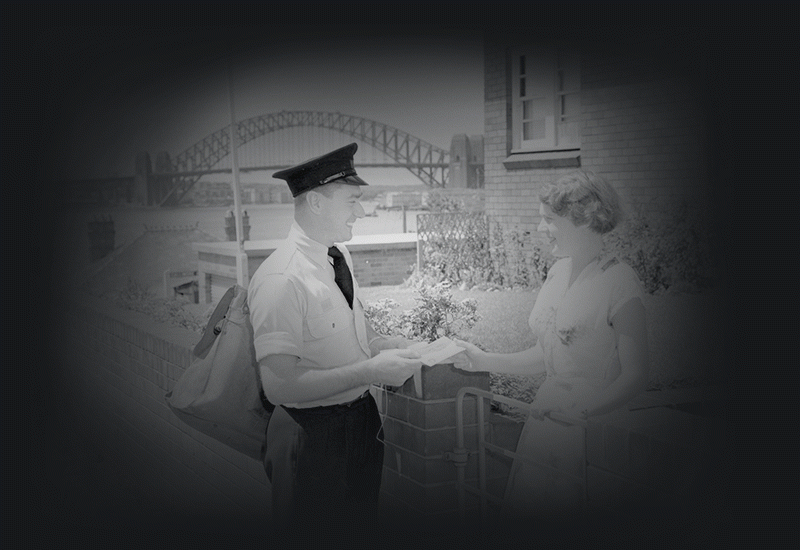 The postman with letter and woman at gate with Sydney Harbour Bridge in background