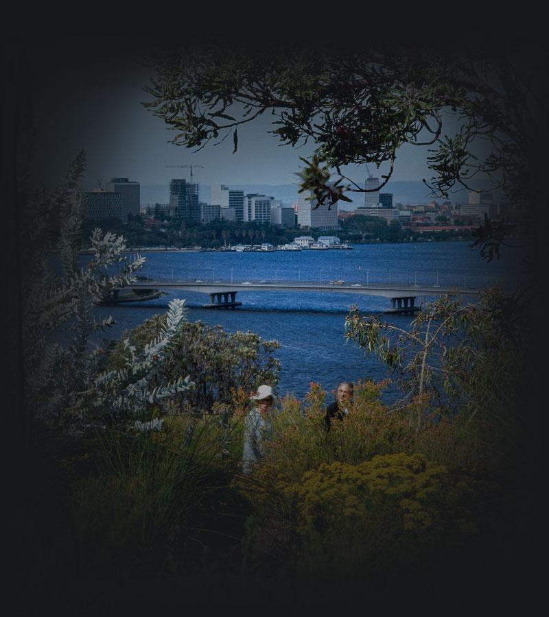 2 people in a botanic garden overlooking a river and city beyond