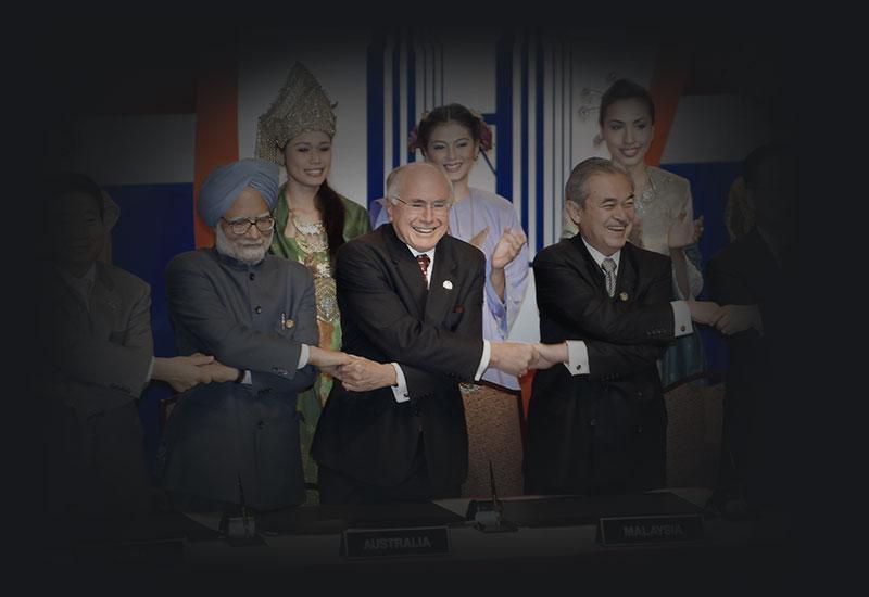 Women wearing National dress stand behind world leaders holding hands