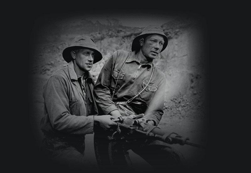 Angell Olsen and his mate Anton Pedersen drill holes for explosive charges, 1952.