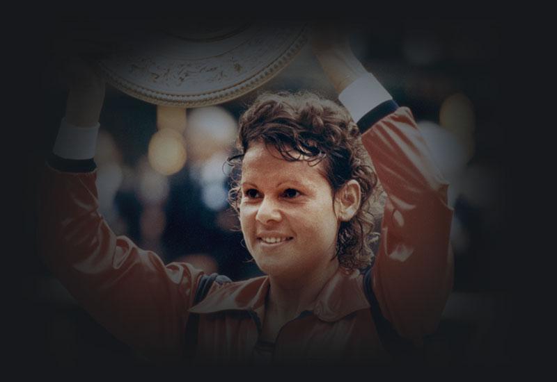 Evonne Goolagong holding the Wimbledon women's singles trophy.