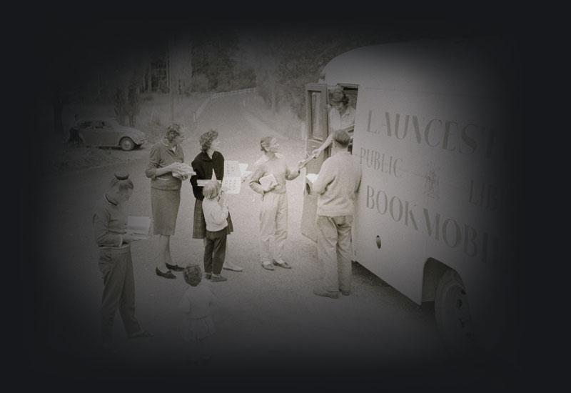 People gather near the open door of a Launceston mobile library bus