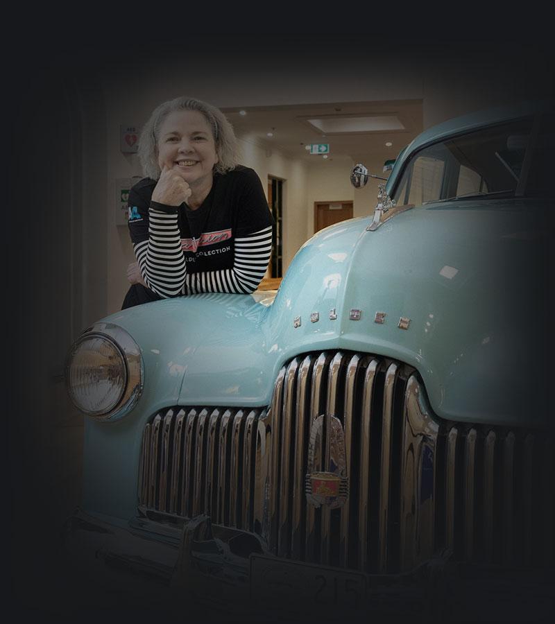 Anna beside a pale blue Holden