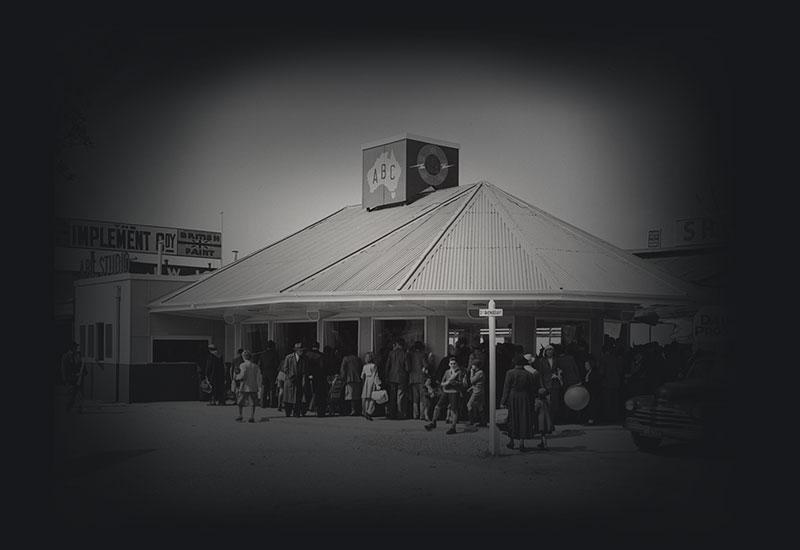 A crowd gather around a small ABC studio building.