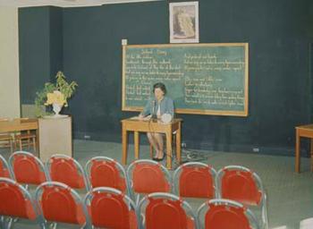A teacher in front of an empty classroom
