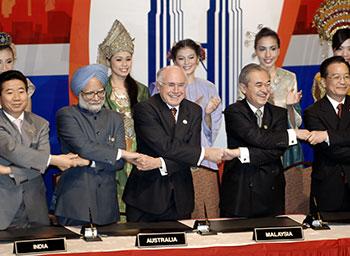 Women wearing National dress stand behind world leaders holding hands