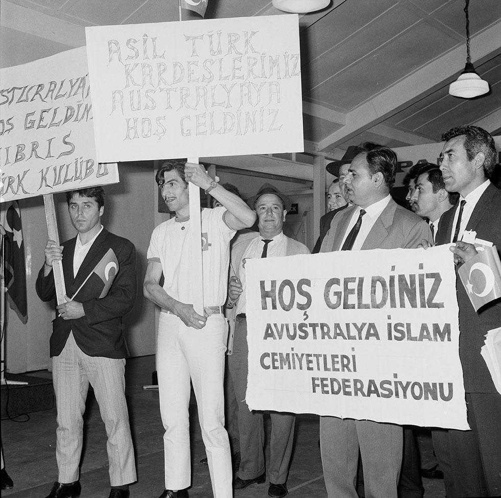 A group of men. Some holding signs written in Turkish Latin script