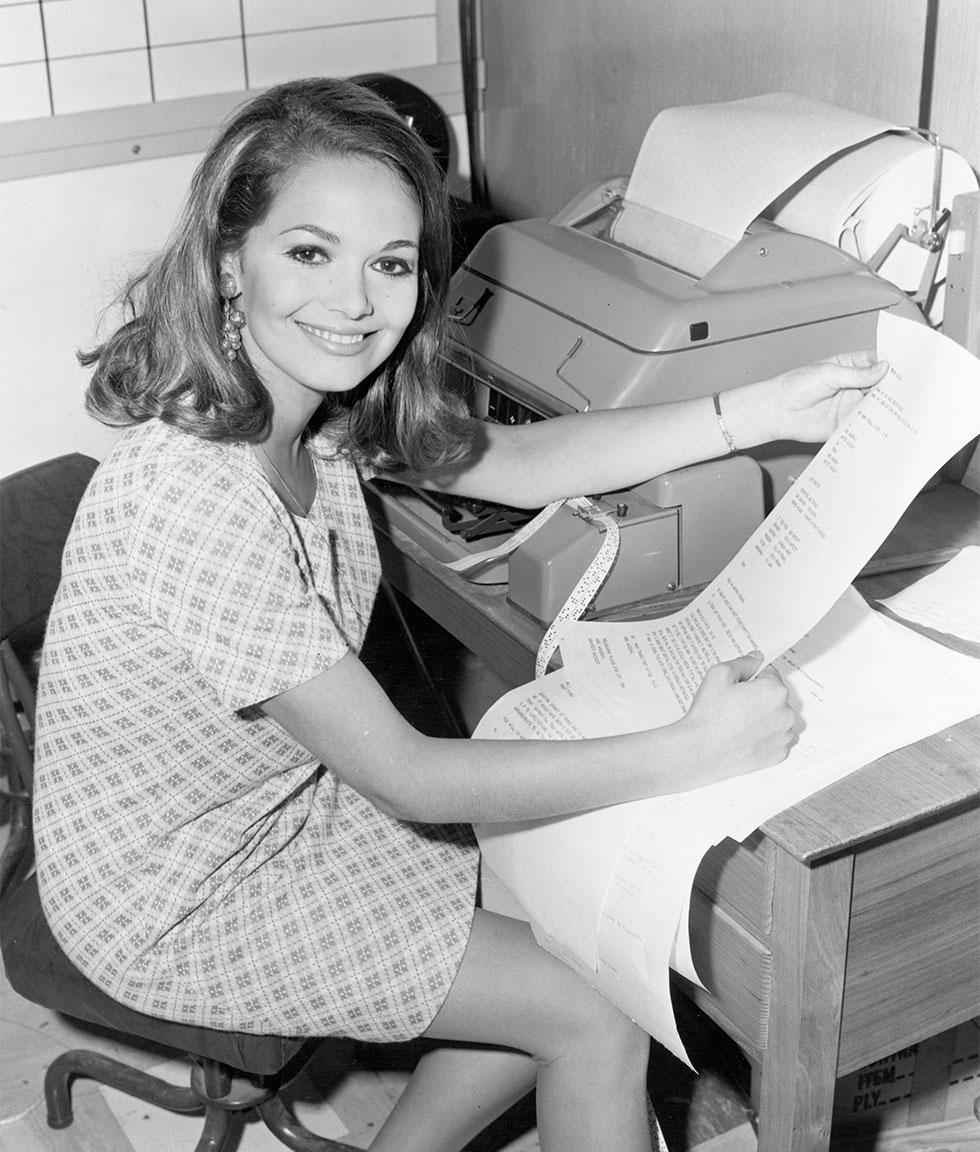 Reporter sitting beside a teleprinter.