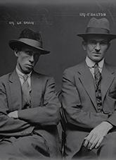 Police photograph of two men wearing 1920's business attire.