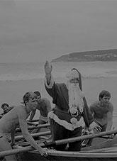 Surf lifesavers and a man dressed as Santa arriving at Manly Beach