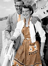 A man and woman standing beside a life boat.