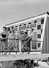 Young people wearing swimming costumes, leaning on a railing at the El Dorado Motel