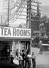 Tea rooms, telegraph poles and people standing on a street corner