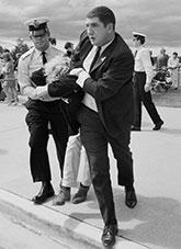 A protester being arrested by 2 police.