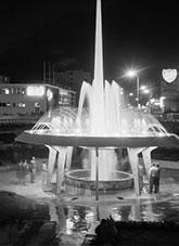 People standing beside the Memorial fountain at the centre of Motel Railway Roundabout, Hobart Tasmania.