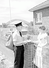The postman with letter and woman at gate with Sydney Harbour Bridge in background