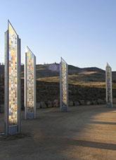 Green hills behind steel columns beside a pond
