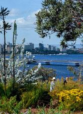 2 people in a botanic garden with views beyond to a city and river