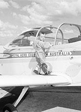 Young child with flight suit and helmet standing on an aircraft wing