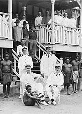 Army officers and Papua New Guinea staff at the entrance to a large timber building.