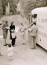People gather near the open door of a Launceston mobile library bus