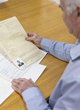 A man looking at a paper immigration record