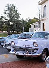 Holden cars from the 50s and 60s parked next to the National Archives of Australia, Parkes