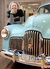 Anna beside a pale blue Holden