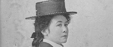 Portrait of Miles Franklin wearing a hat and holding a parasol.