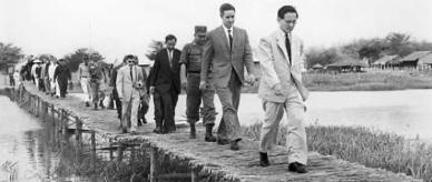 Officials dressed in suits and uniform crossing a bridge at Ong Nhan, South Vietnam. 