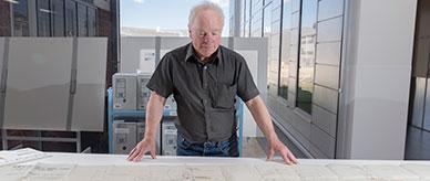 A man looking at a mechanical engineering drawing: cruising turbine in a ship engine room.
