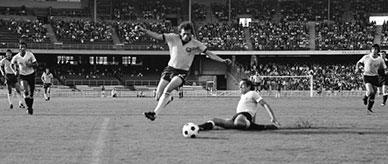 A football player evading an intercept during the World Cup match between Uruguay and Australia.