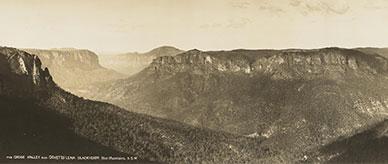 Forested valleys between table-top mountains with sandstone cliffs.