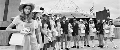 Uniformed expo hosts gathered near a futuristic pavilion.