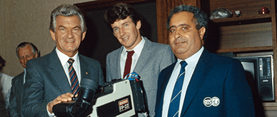 Bob Hawke with Overseas Telecommunications Commission officers with a video camera on timber tripod.