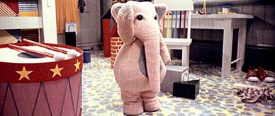 A person wearing a pink elephant costume