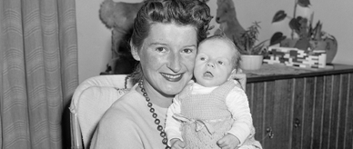 Adriana smiling and holding her baby Ricky. 