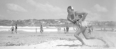 A Bondi Beach surf lifesaver running toward the water