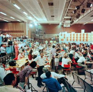 A crowded Tally room featuring red chairs and red telephones.