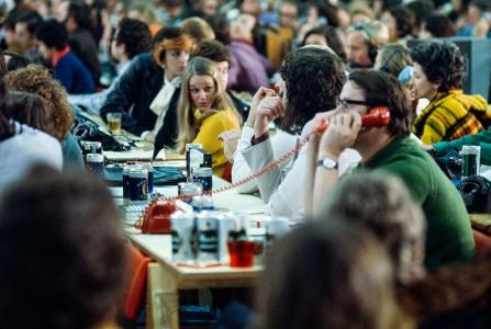 Beer cans on desks, a red telephone and colourful clothing of the tally room crowd.