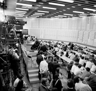 A double height tally board and people at desks fill the high school hall.