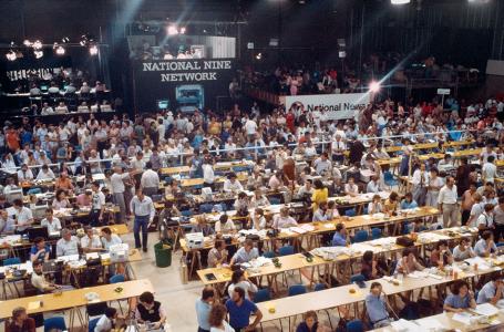 A crowded room with long rows of desks dominated by National Nine Network's tall platform.